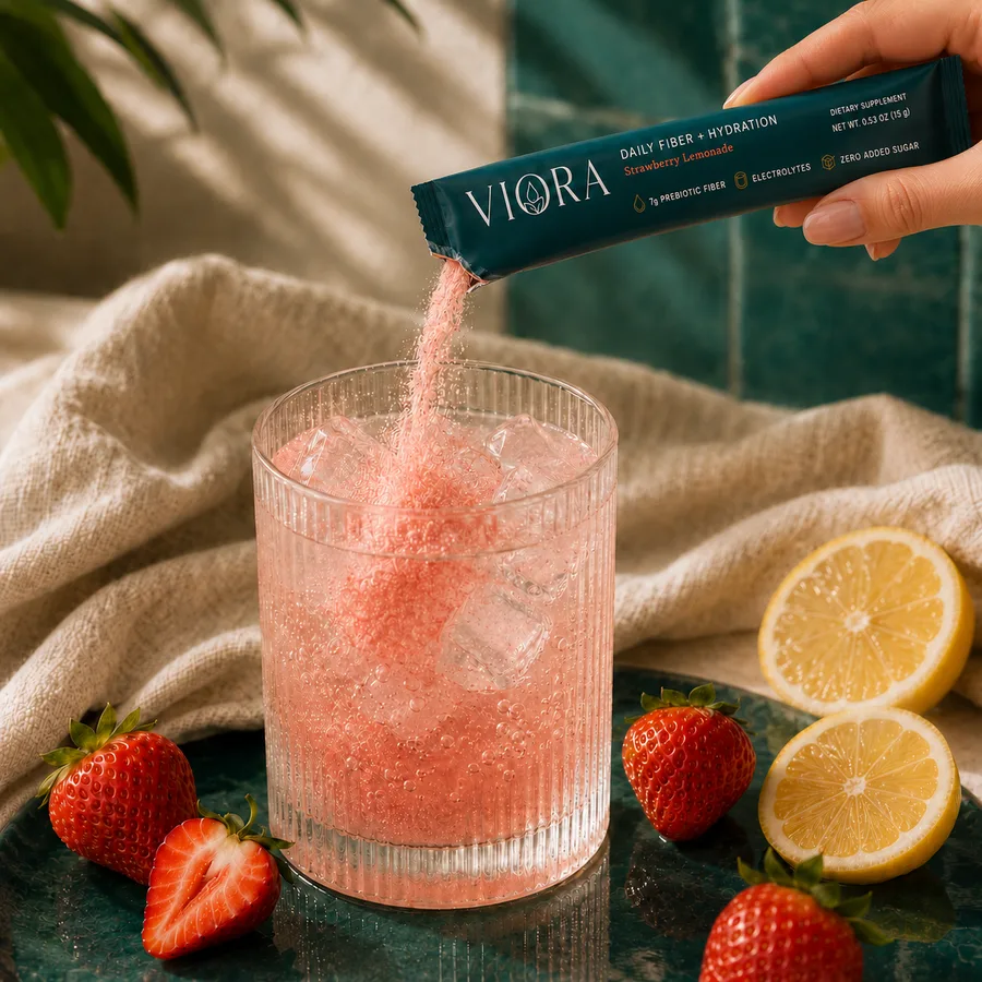 Viora powder pouring into a ribbed glass of sparkling water
